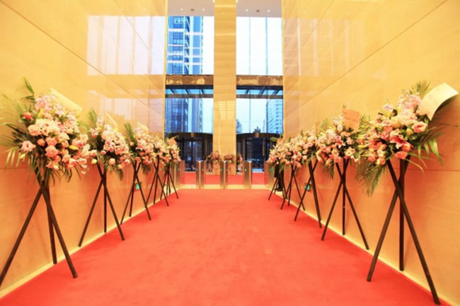 一路红毯与鲜花将现场氛围彰显得异常热烈而又充满朝气.